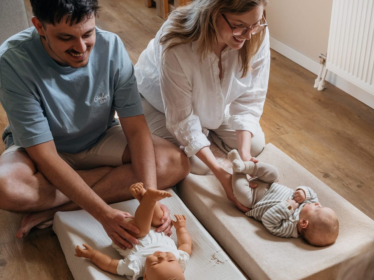 hero — ouders die hun baby masseren op het matje